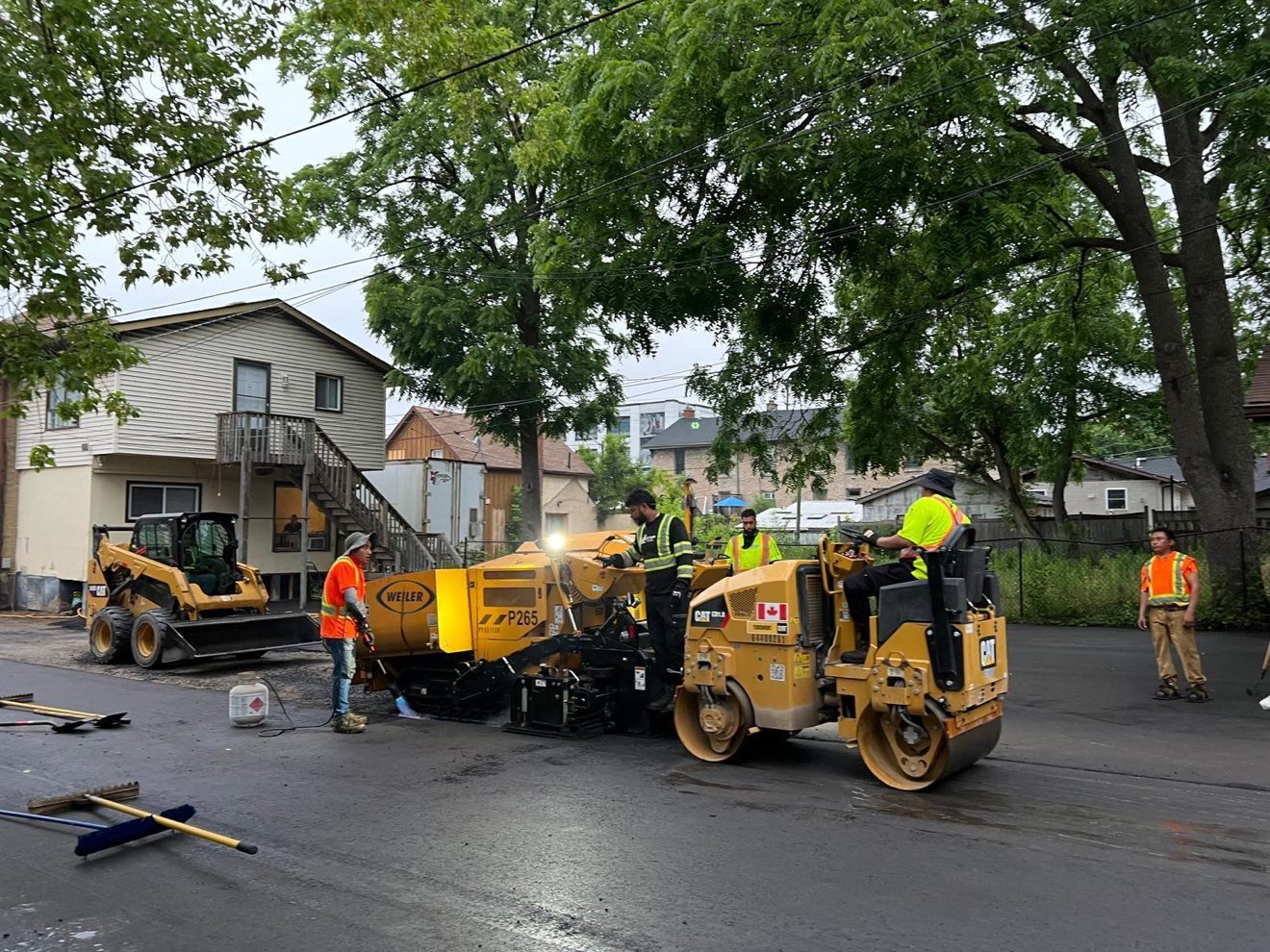 Next Gen crew paving a parking lot with the Weiler P265 paver and CAT roller